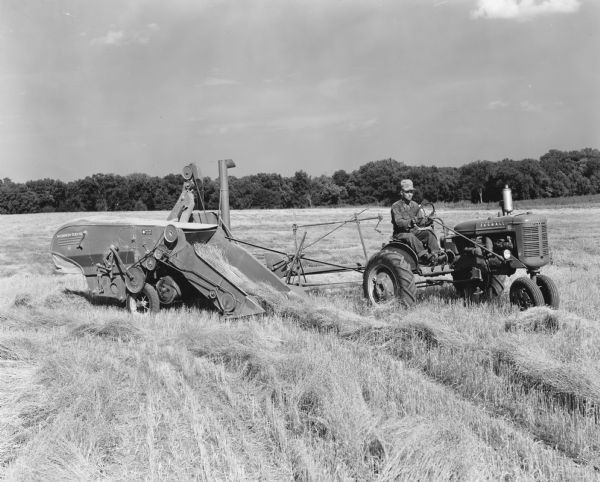 Original caption reads: "I-2618-EE, I-2623-EE, I-2625-EE and I-2624-EE. Taken on the farm of Mr. Marvin Dyer, the IHC dealer of Falls City, Nebraska and Hiawatha, Kansas. His farm is five miles west of Falls City, Nebraska. Here is shown his B tractor and 42 combine with the pickup attachment working in flax. In this part of the country there is not much flax grown and there-fore is not considered in the government program, so it can be planted on idle land. here Mr. Dyer has planted 43 acres of flax, he has cut it with a binder leaving off the string and letting it go straight through the machine in windrows, after drying thoroughly he is picking it up as you see. The Flax is $1.54 per bushel and will make from to 15 to 18 bushels per acre here. This is pretty good for land that has been cut out of the farmers program. One thing that makes raising this crop so good is that rain on it when it is drying cannot hurt it, it is so full of oil. All our other crops spoil if rained on while drying. Flax can no be cut with the mower as it gives the combine too much tough roughage to handle. Of course, it can be done, but is not so good. In this field he started wit the mower and cut one round and changed to the binder. Flax has a very tough stalk."