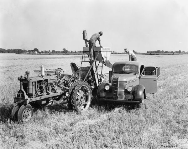 Original caption reads: "Unloading wheat from IHC No. 61 combine on the Purdue University farm near West Lafayette, Indiana." Pictured along with the No. 61 combine is a McCormick-Deering F-20 tractor and what appears to be D line truck from International.