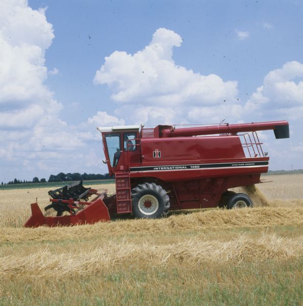Left side view of man driving a 1460 combine in a field.
