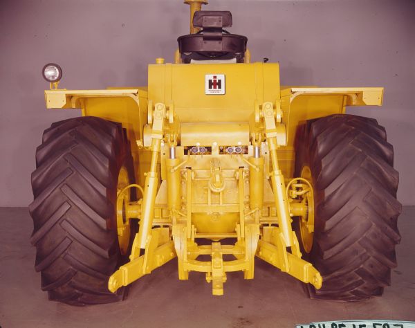 Rear view of an International Harvester 4100 tractor parked indoors. It has been painted yellow.
