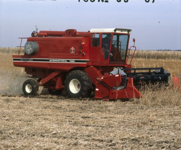 Man operating a 1420 combine with 820 header in a field of soybeans.