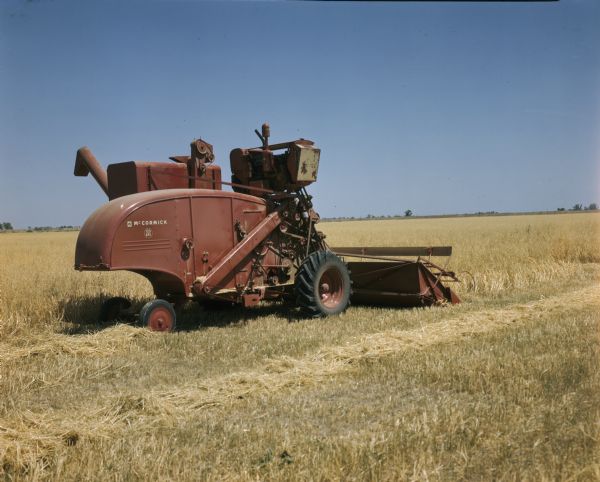 Three-quarter rear view from right of a McCormick combine 125 SPX in a field.