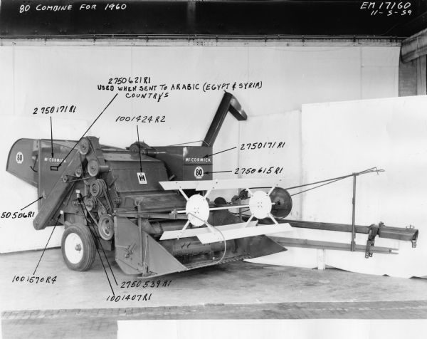 Three-quarter front view studio shot of a McCormick No. 80 combine for 1960. Image includes hand annotated numbers with arrows. 