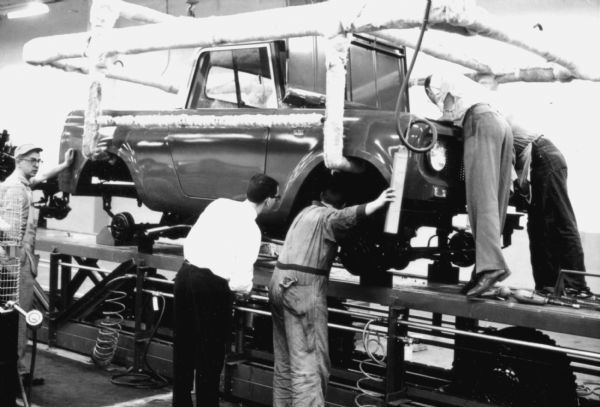 Five Fort Wayne employees load an International Scout body onto its chassis. Assembly line image from International Harvester's Fort Wayne plant, subject of a 1961 article in <i>International Harvester Today</i> entitled: "The Scout."