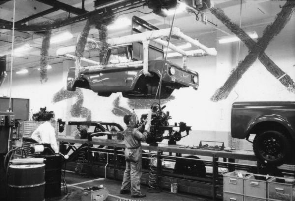 Several Fort Wayne employees are bracing the chassis of an International Scout as they prepare to unite body and chassis. Assembly line image from International Harvester's Fort Wayne plant, subject of a 1961 article in <i>International Harvester Today</i> entitled: "The Scout."