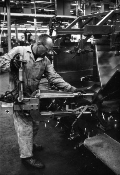 Fort Wayne employee using power tool to assemble the body of an International Scout. Assembly line image from International Harvester's Fort Wayne plant, subject of a 1961 article in <i>International Harvester Today</i> entitled: "The Scout."