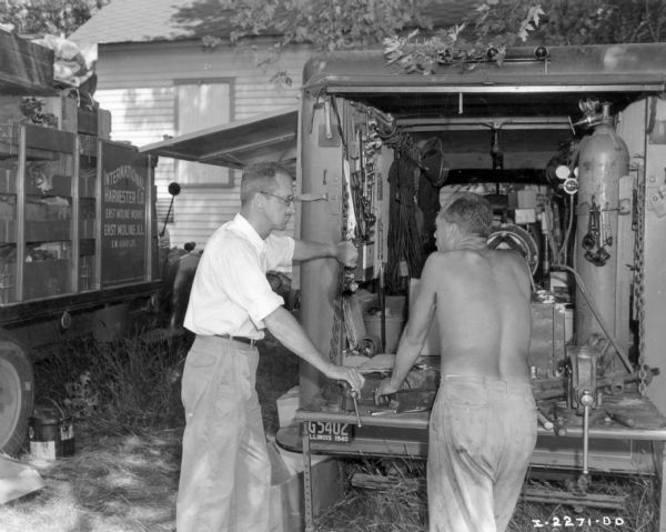 R.T. Quinby, field engineer, explaining caravan shop truck to Fowler McCormick.