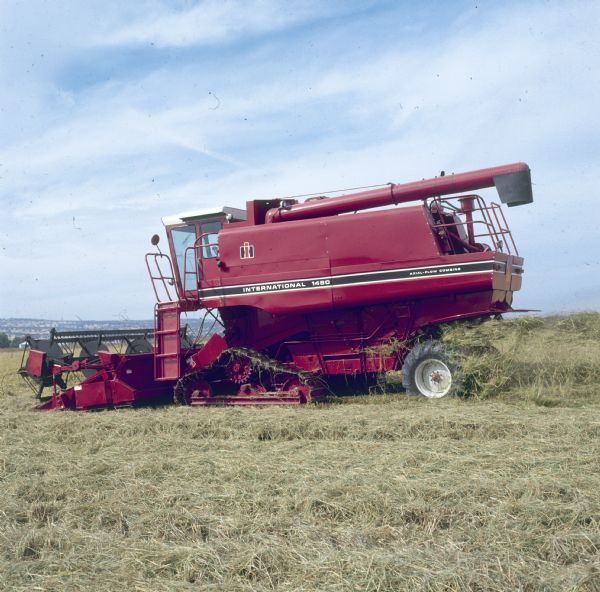Left side view of a 1480 Rice Combine in a field.