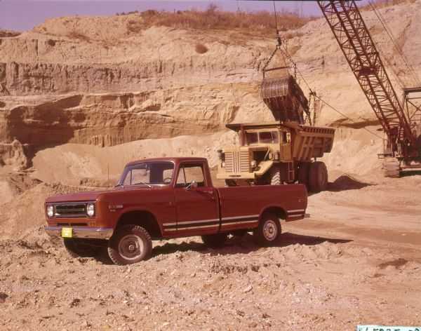 D-Line model pickup. 1100-D 4x4 1/2 ton pickup. In the background a crane is loading an International Pay Hauler.