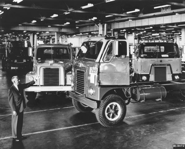 Last DCO-400 cab over truck rolling off the production line. Total production of 32,855 trucks came off the line in October of 1965 at the San Leandro, California factory. In the background are the new models, CO-4000, cab over, and a conventional DC-400. Standing on the left is J.W. Zimmerman, Jr., and standing in the driver's seat with the door open is Floyd Poff.