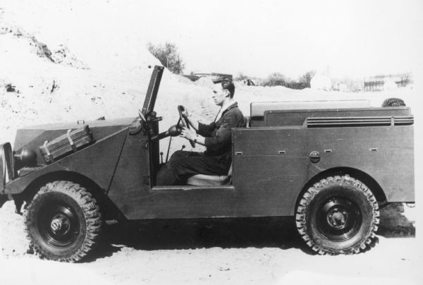 Driver's side view of a man driving a 4x4 Scout chassis.