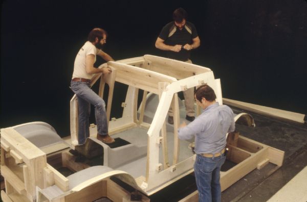 Slightly elevated view of three men working on a Scout model.
