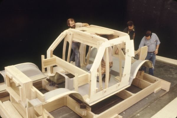 Slightly elevated view of four men working on a Scout model indoors.