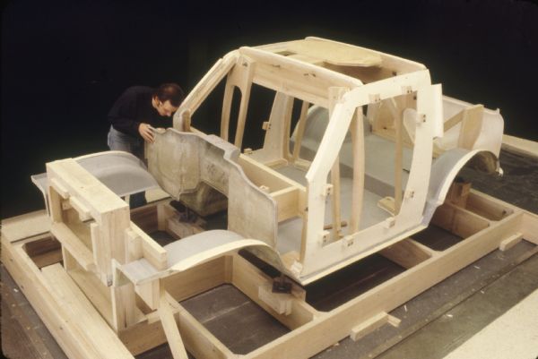 Slightly elevated view of a man working on a Scout model indoors.