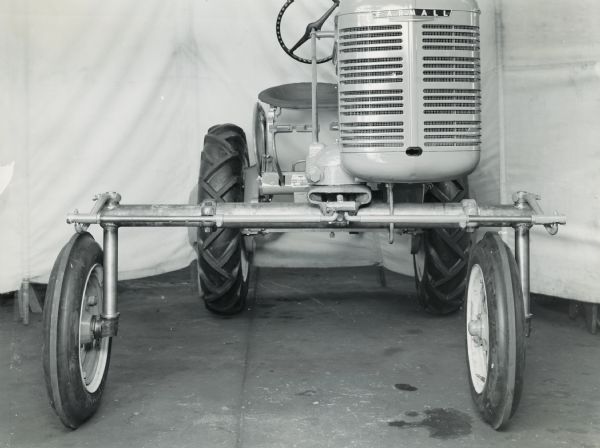 Farmall A tractor. Full adjustable front axel[sic] (right side open, left side closed position). A white backdrop hangs in the background.