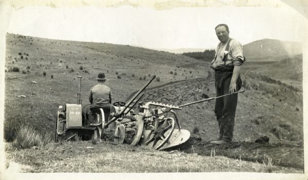 Two men plow this New Zealand landscape using a McCormick-Deering 10-20 tractor and plow.