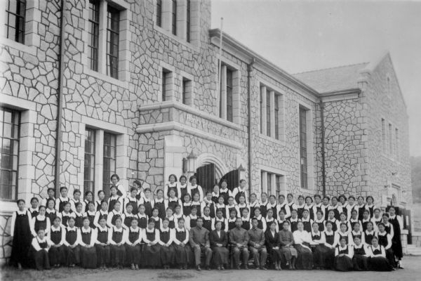 Original caption reads: "Students and Faculty of Central Kindergarten College, Seoul, Korea, with main building in background. Photograph given by Mrs. Louise Yim Hahn, on the occasion of her call at NF Mcc BA Rooms, March 6 1939."