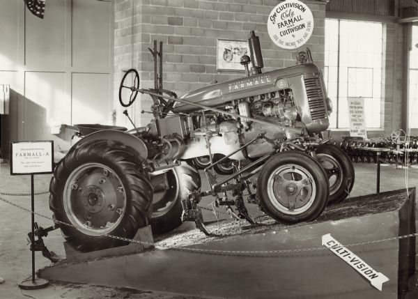 Right side view of Farmall A on display on a ramp indoors at the New York State Fair. An arrow sign on the ramp reads: "Culti-vision."