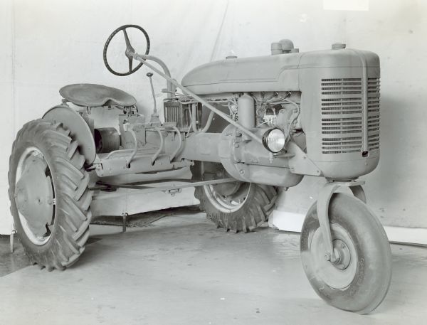 Three-quarter view from front of left side of a Farmall B tractor with attach's. 2nd preproduction type.