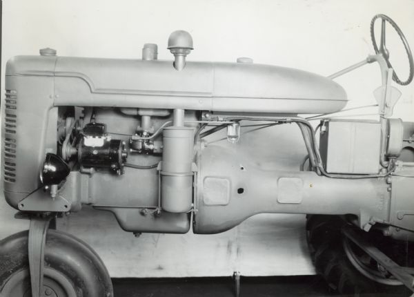 Close-up view of front left side of a Farmall B tractor with lighting attach. showing generator & etc.