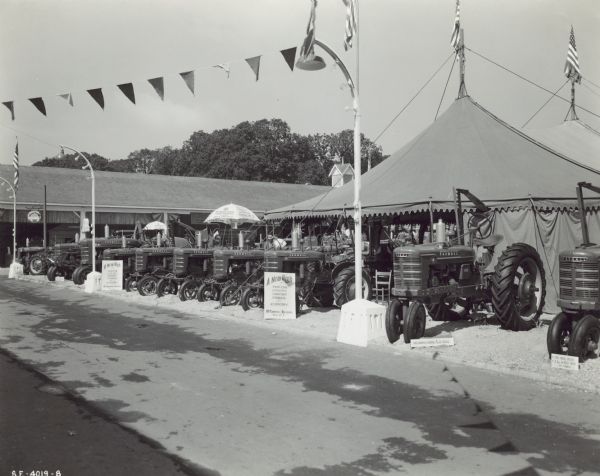 Row of Farmall tractors on display outdoors at the Oregon State Fair.