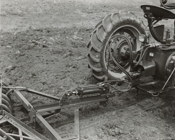 Close-up of back of Farmall M tractor and 8 foot No. 10A disk harrow equipped with remote control hydraulic cylinder.