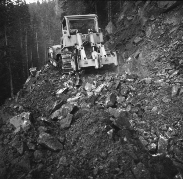 International TD-25C clearing earth along the side of a steep hill in preparation for construction.