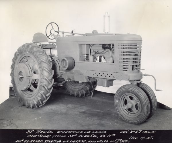 Prototype design of a Farmall 3F, which would later become the Farmall M. Original caption reads: "3F Tractor with starting and lighting. Belt pulley attach job #AC-22520, WT. 99#. job# HG-22520 Starting and Lighting, assembled on Q#2830. Neg. No GP 13614. Nov 17-38."