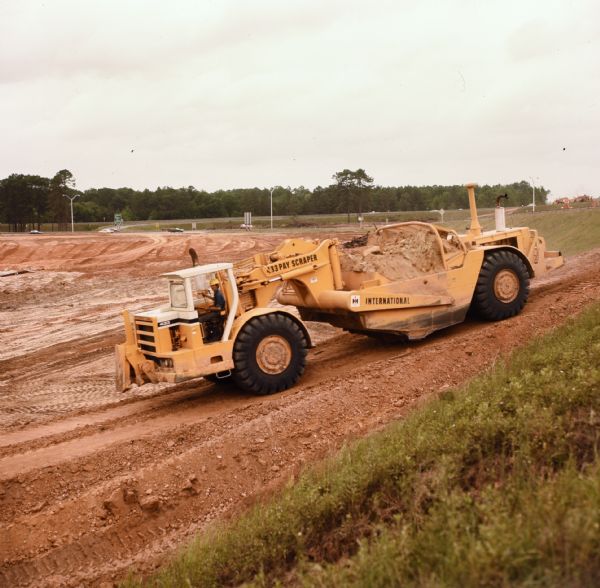 Man operating a 433 Pay Scraper. Shepherd Construction Company, Inc., has sub-contract for grading and drainage work on section of Georgia Route 333.