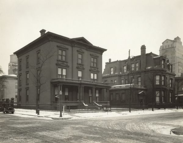 Southwest view of 50 E. Huron Street. This house was the residence of Cyrus McCormick Jr. Snow is on the ground. Tall buildings and a water tower are in the far background. Original caption reads: "Frank S Fulton, Photographer - Jan 1929.  50 E Huron St, Chicago (2nd house from left.) Southwest view House at left is 40 E Huron St occupied by Mr. and Mrs. John H Witerbotham."