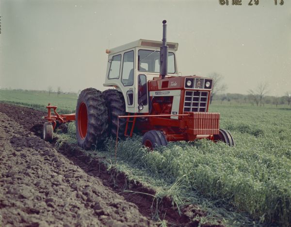 Three-quarter view from front right of a man using a 4366 Turbo tractor in a field.