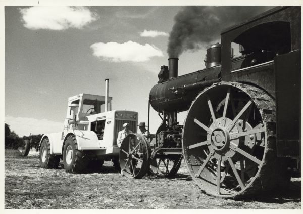 Tractor and steam tractor outdoors.