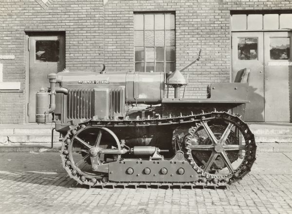 Left side view  of a McCormick-Deering tractor parked outdoors. Caption: "Enlarged front idler for 15-30 tractor.