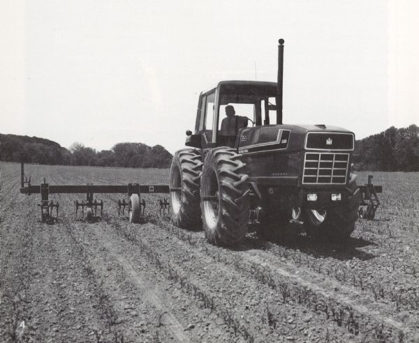 View from front right of a man driving a 3388 tractor in a field.
