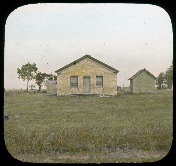 View across lawn towards a rural schoolhouse near Williams Bay. Hand-tinted lantern slide.