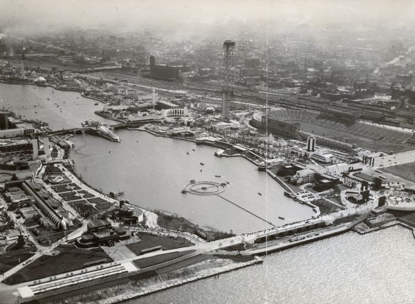 Aerial view towards the southwest of International Harvester's. Burnham Harbor is in the center, with exhibit buildings on the left on Northerly Island, and Soldier Field and the city of Chicago on the right.