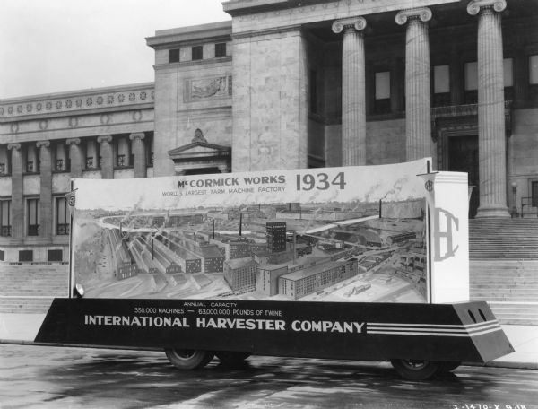 International Harvester Company parade float for the "A Century of Progress" Worlds Fair. This is the front section of the two-section float, and it is parked in front of the Field Museum and reads: "McCormick Works, 1934, World's Largest Farm Machine Factory."