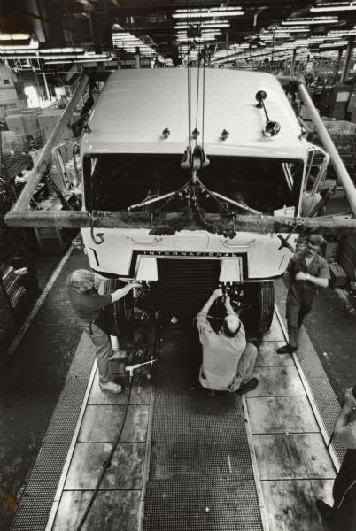 Elevated view of men working on assembly line on factory floor.