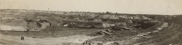 Panoramic view of Hawkins Mine, with railroad tracks in the foreground. Buildings and a water tower are in the distance.
