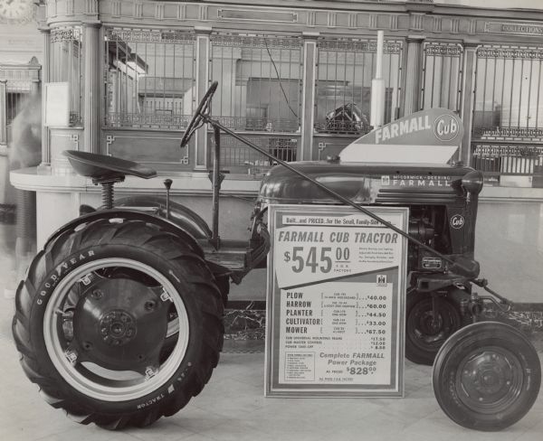McCormick-Deering Farmall Cub tractor on display at a Great Falls, Montana branch meeting. A sign on the tractor advertises the price of the tractor and various implements.
