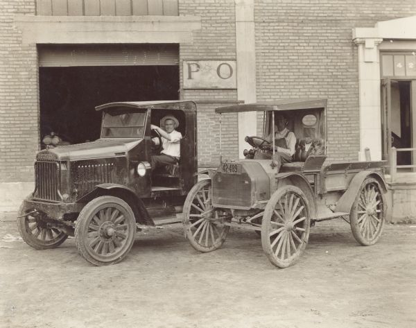 Two men in International Model 63 and MW Trucks. A brick building is behind them, with an open garage door, and a sign that reads: "P&O Light Draft Plows." Back of print has text that reads: "Model 63 & MW. A B Reynolds, Chadwick, Mo." The truck on the right has a Missouri license plate.