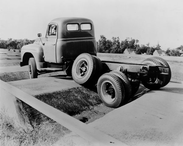 Caption reads: "Close by International Harvester Company's mammoth new motor truck engineering building and laboratories is the Fort Wayne proving ground, where pilot model trucks are put through accelerated tests simulating the conditions of actual operation. Here a six-wheeled International L-180 paces through the long, racking 'twist course' which subjects its frame, springs, wheels and other components to severe test. Measured results of proving ground tests are studied closely by International truck engineers engaged in consistent, year-round effort to improve further the efficiency and economy of truck operation."