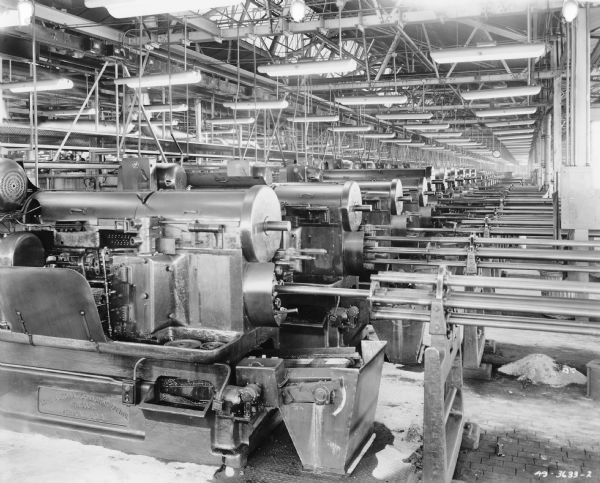 Rows of Automatic Screw Machines on factory floor. Stamped on machine: "Cone Automatic Machine Co. Inc. Windor. Vermont, U.S.A."