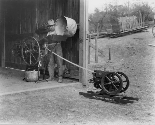 Farmer using a McCormick-Deering 1 H.P. stationary engine.