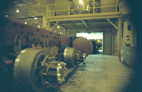 Machinery in factory. A man is in the background on the right.