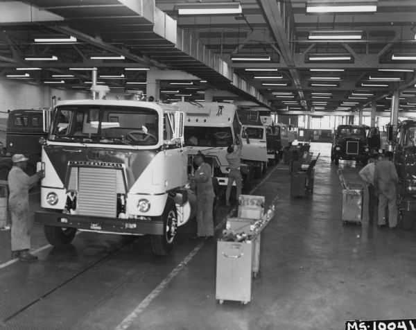 Caption reads: "On the main assembly line at its San Leandro works, trucks up to 90,000 pounds gross vehicle weight are produced by International for the needs of western truck operators. Highly specialized trucks of lower production volume are built on companion line."
