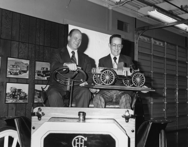 Attached letter from the Springfield Plant in Ohio reads, in part: "Attached are photos of Robert E. Brown, the model builder, presenting the model to Mr. Mazurek for G. O. Archives. The model will be carefully packed and covered with a plexiglas display cover before it is sent to Archives." The two men are sitting in an auto wagon.