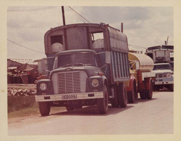 International Harvester truck on a road in Vietnam. Other trucks are behind on the right. The trucks were used to haul goods from the different provinces to Saigon, a city of three million people, many of whom have fled their country homes to the city because of the war.  Report states: "Trucks used to carry vegetables from Da Lat (Central Highlands) to Saigon, over a distance of 300 kilometers. To travel from Da Lat to Saigon takes 6.5-7 hours. The roads are in good-fair condition." Description of equipment: City: Cholon. Loadstar 1700, 3 years old, standard; RA-146 Used.