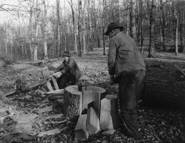 Handwritten on back: "2. Man at right is taking out the heart wood. 6. Man at left is finishing completed shingles with draw knife."