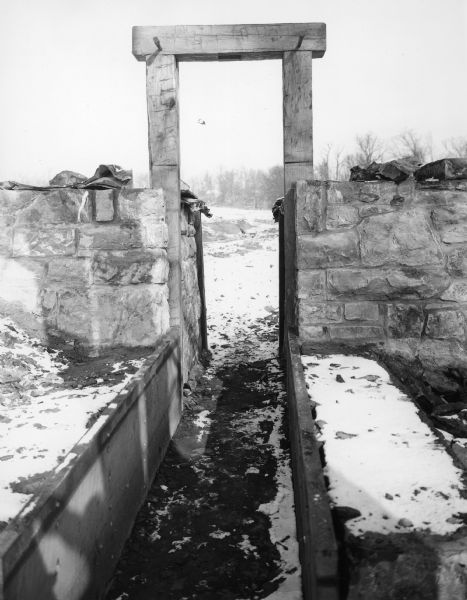 Handwritten on back: "View of head gate entrance taken from outside of dam. Note hand hewn locust posts."
